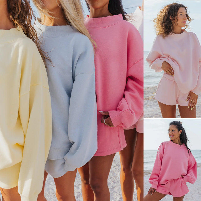 Load image into Gallery viewer, Three women wearing pastel-colored sweatshirts and shorts on a beach.