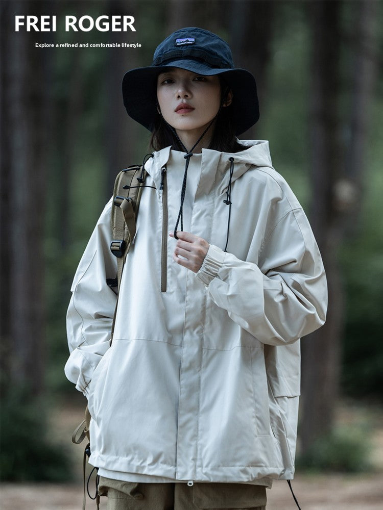 Load image into Gallery viewer, Person wearing a beige jacket and blue hat in a forest setting with 'FREI ROGER' branding.