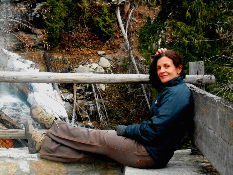 Model sitting on bench at a waterfall